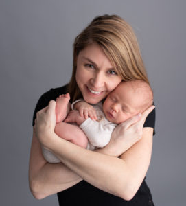 This is a newborn photography image of a mother and Newborn Baby with grey back drop