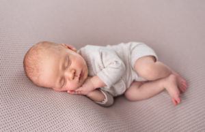 This is a newborn photography image of a Newborn baby doing side lying on beanbag