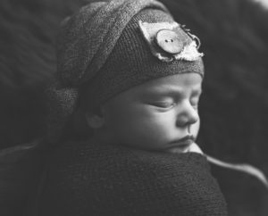 This is a newborn photography image of Newborn Baby boy in sleepy cap in Black and White