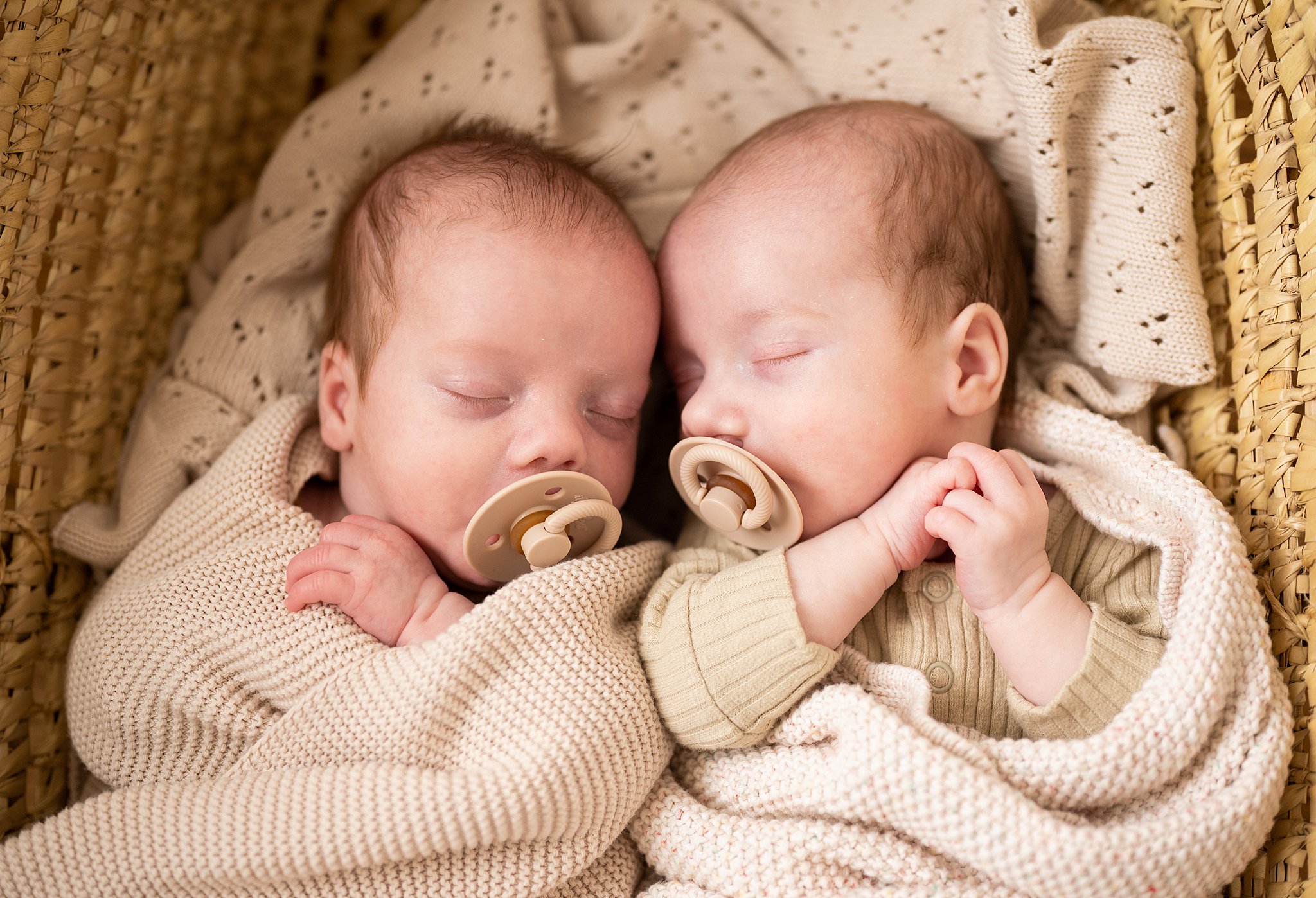newborn twins sleep in a basket wearing brown onesies Ottawa Birthing Centre