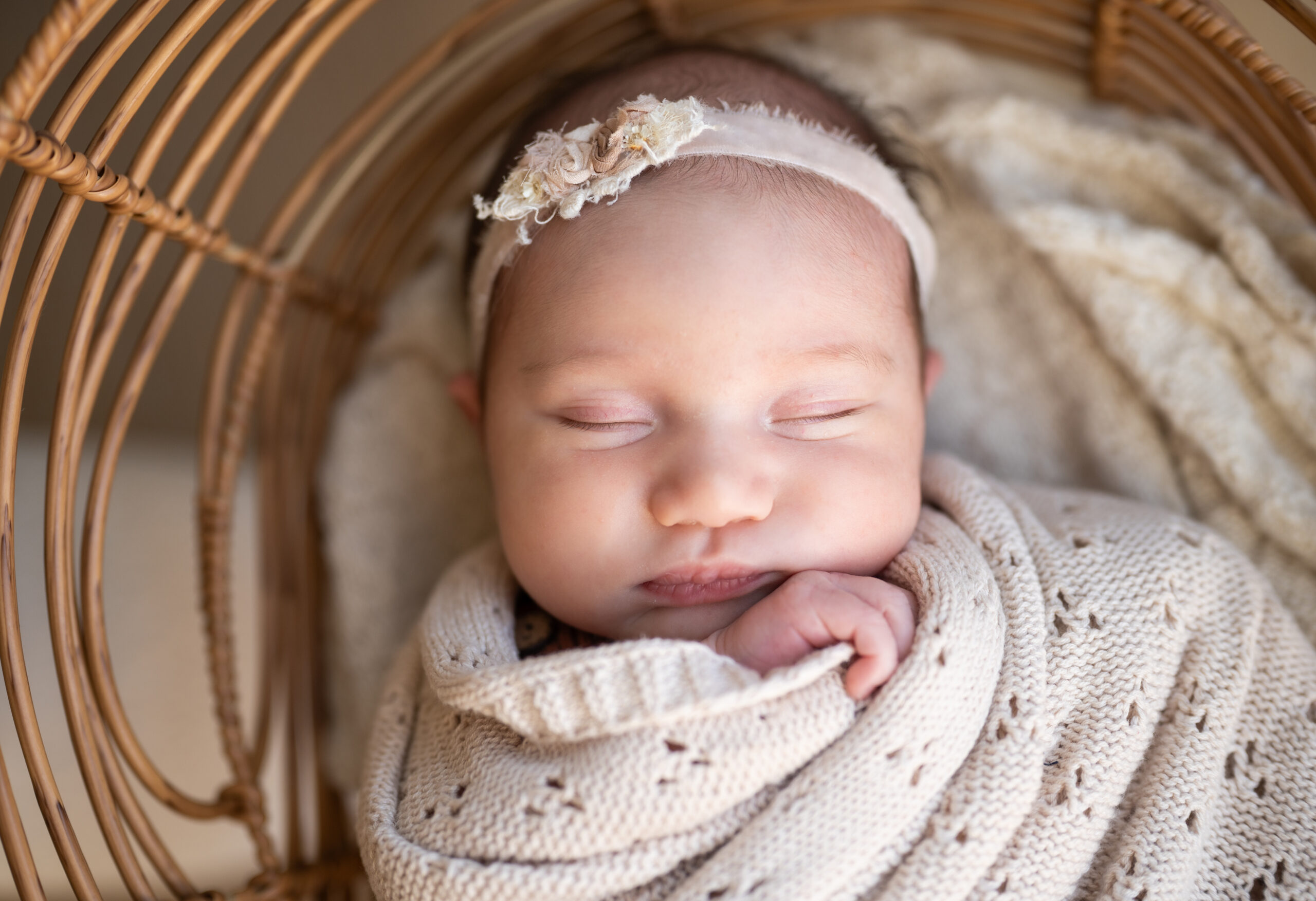 newborn baby wrapped in beige blanket sleeping